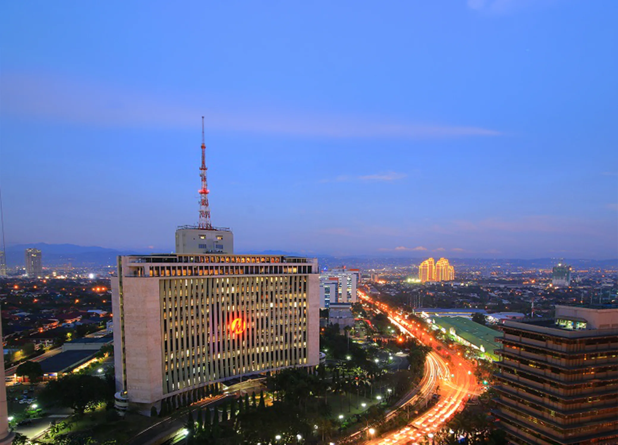 The Meralco headquarters and Ortigas skyline illuminated at dusk.