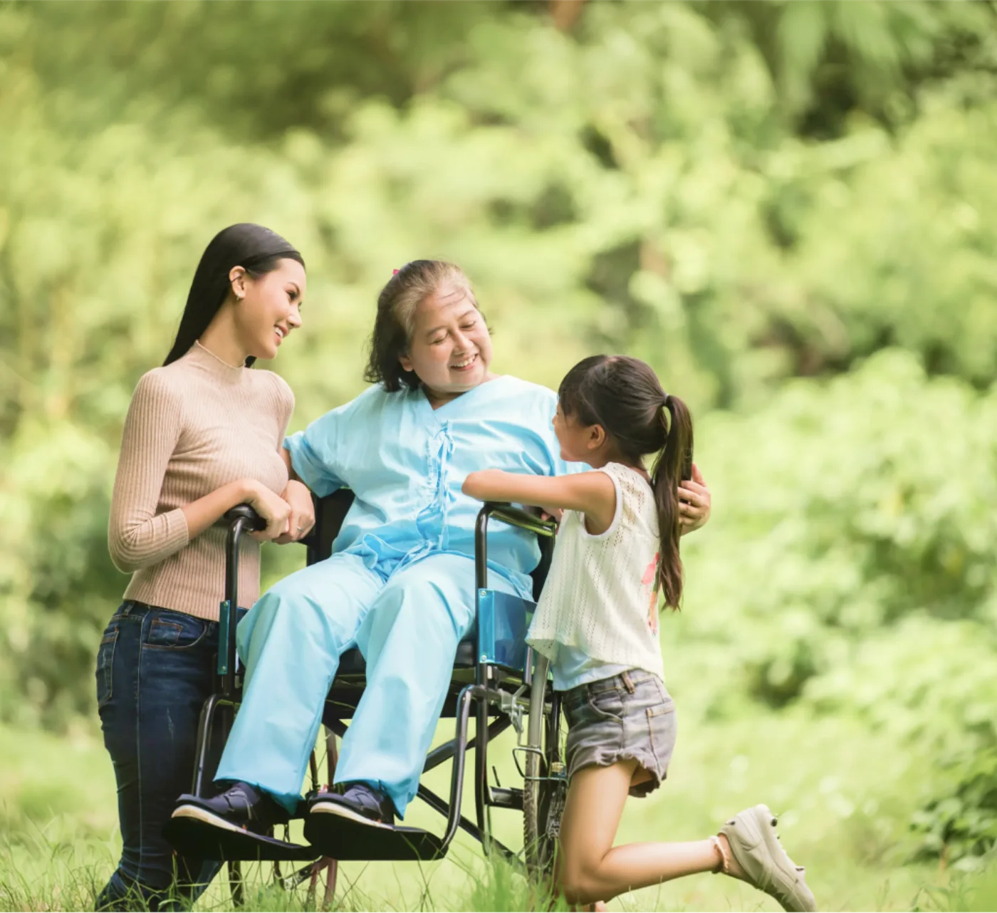 A family enjoys time together with an older relative in a park.