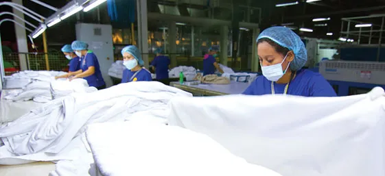 Employees handle textiles at the production facility.