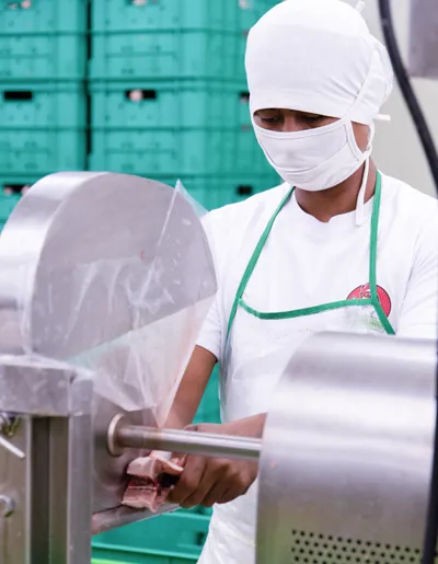 Farmrich Foods employee operates food-processing equipment.