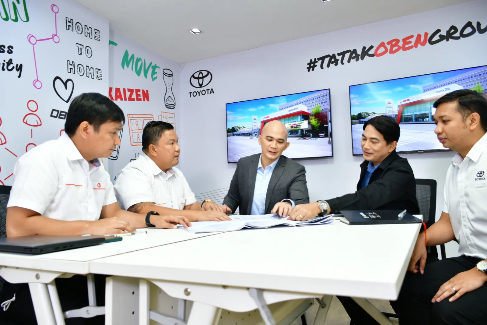 Toyota Oben Group and Meralco representatives sign an agreement.