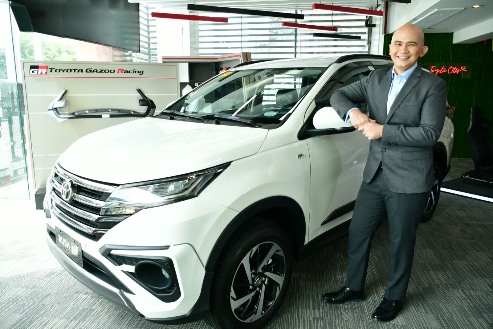 Toyota Oben Group representative beside a vehicle.