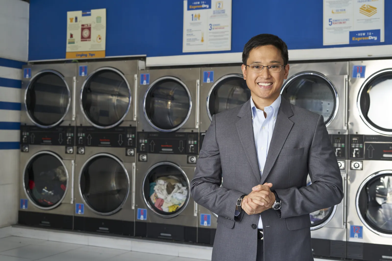 ExpressWash representative in front of washing machines.