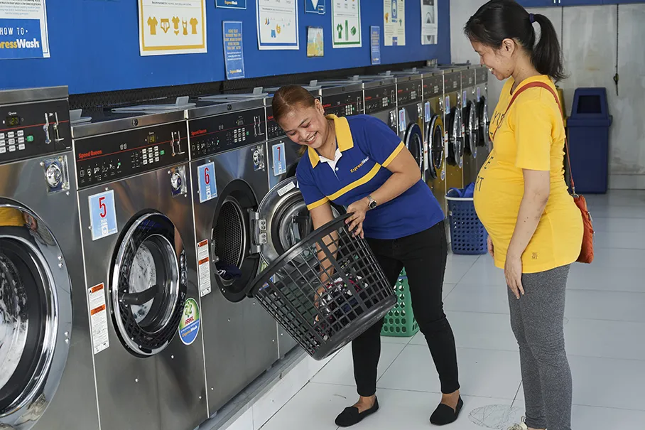 ExpressWash employee assists a laundry customer.