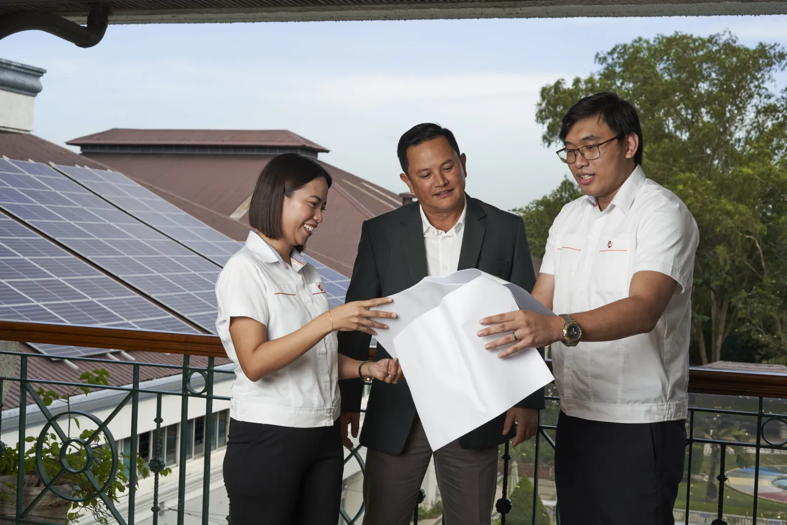 Orchard representatives beside solar panels.