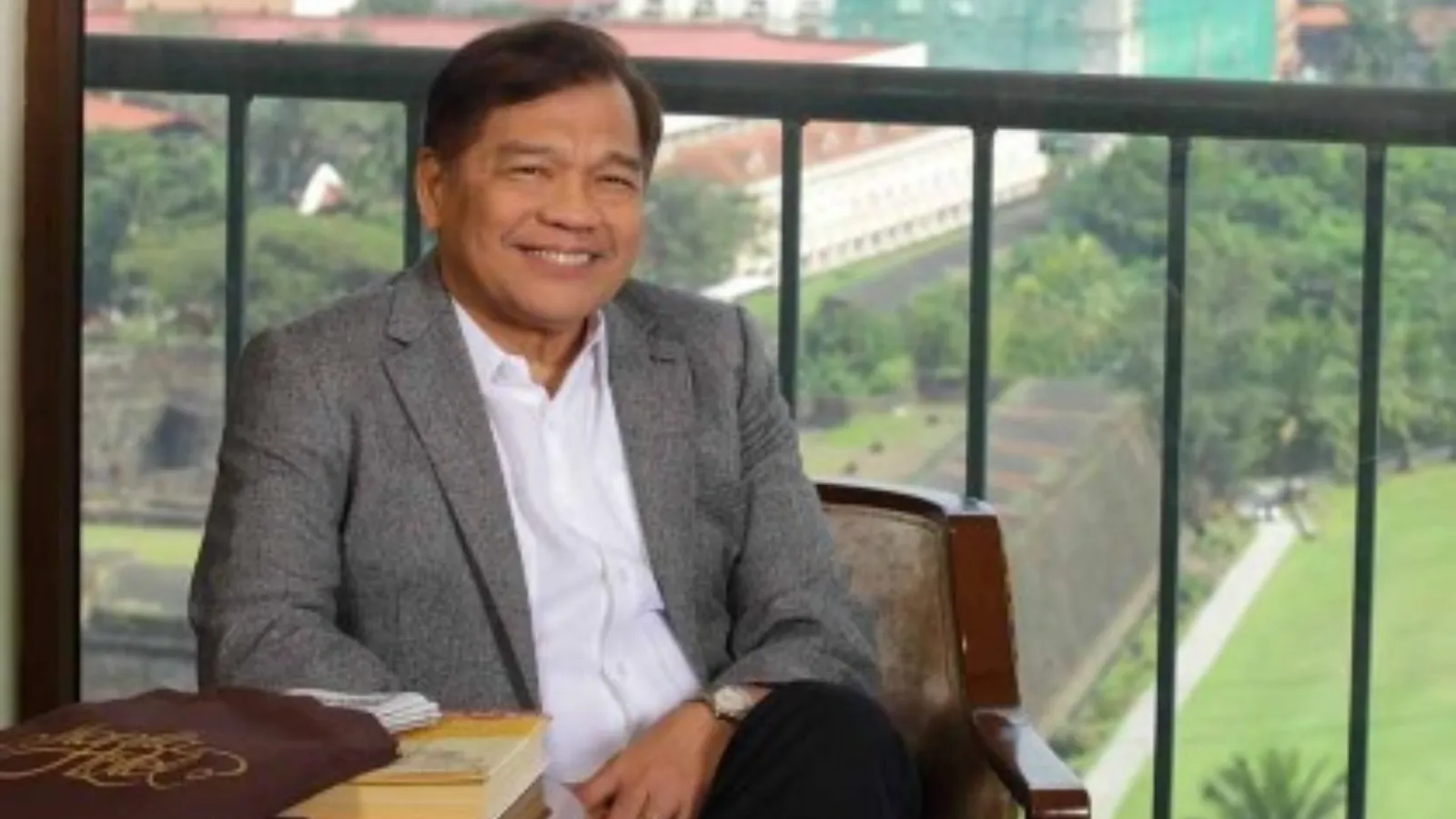 Manila Hotel representative seated beside a window.