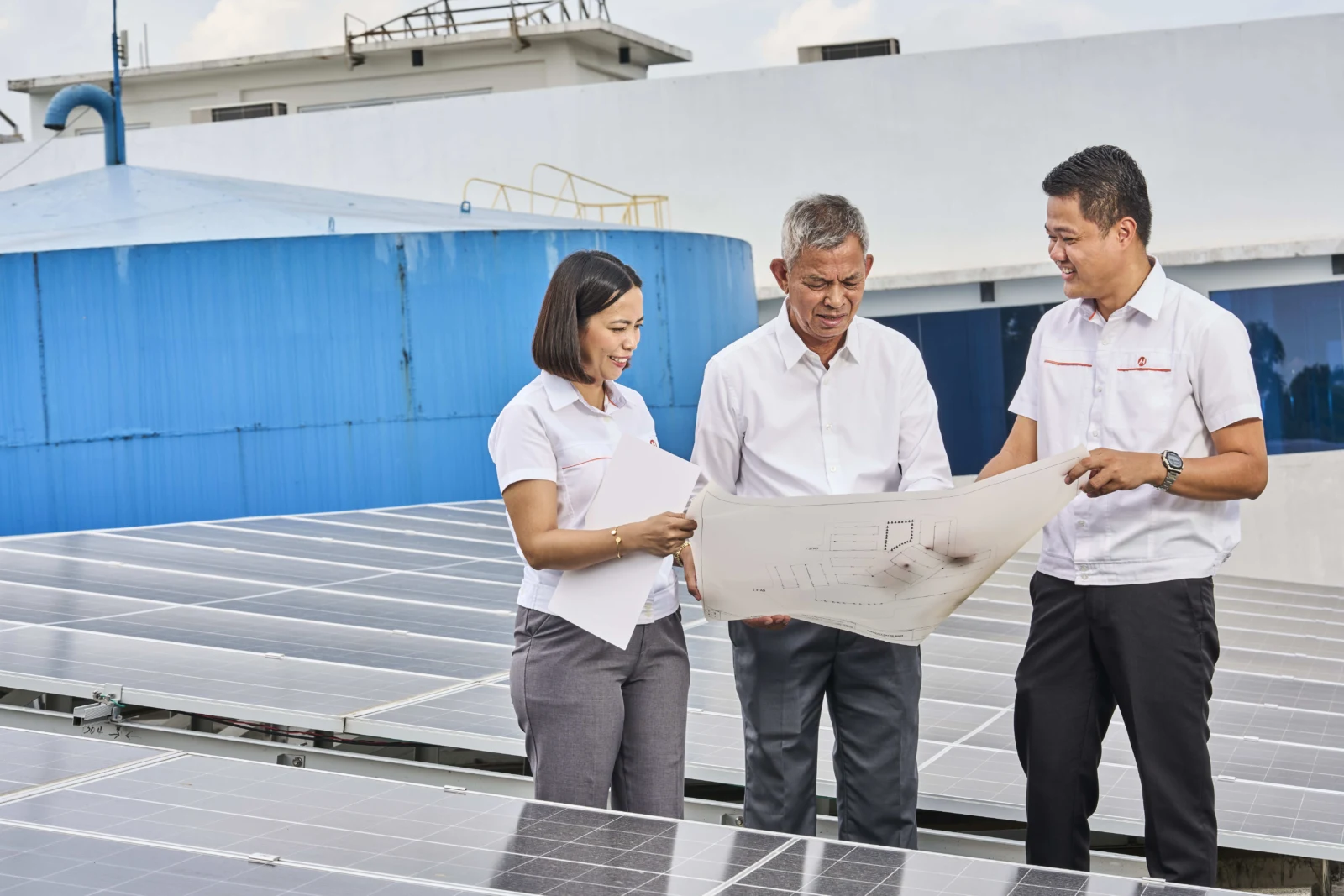 Meralco representatives reviewing a site plan beside a business facility.