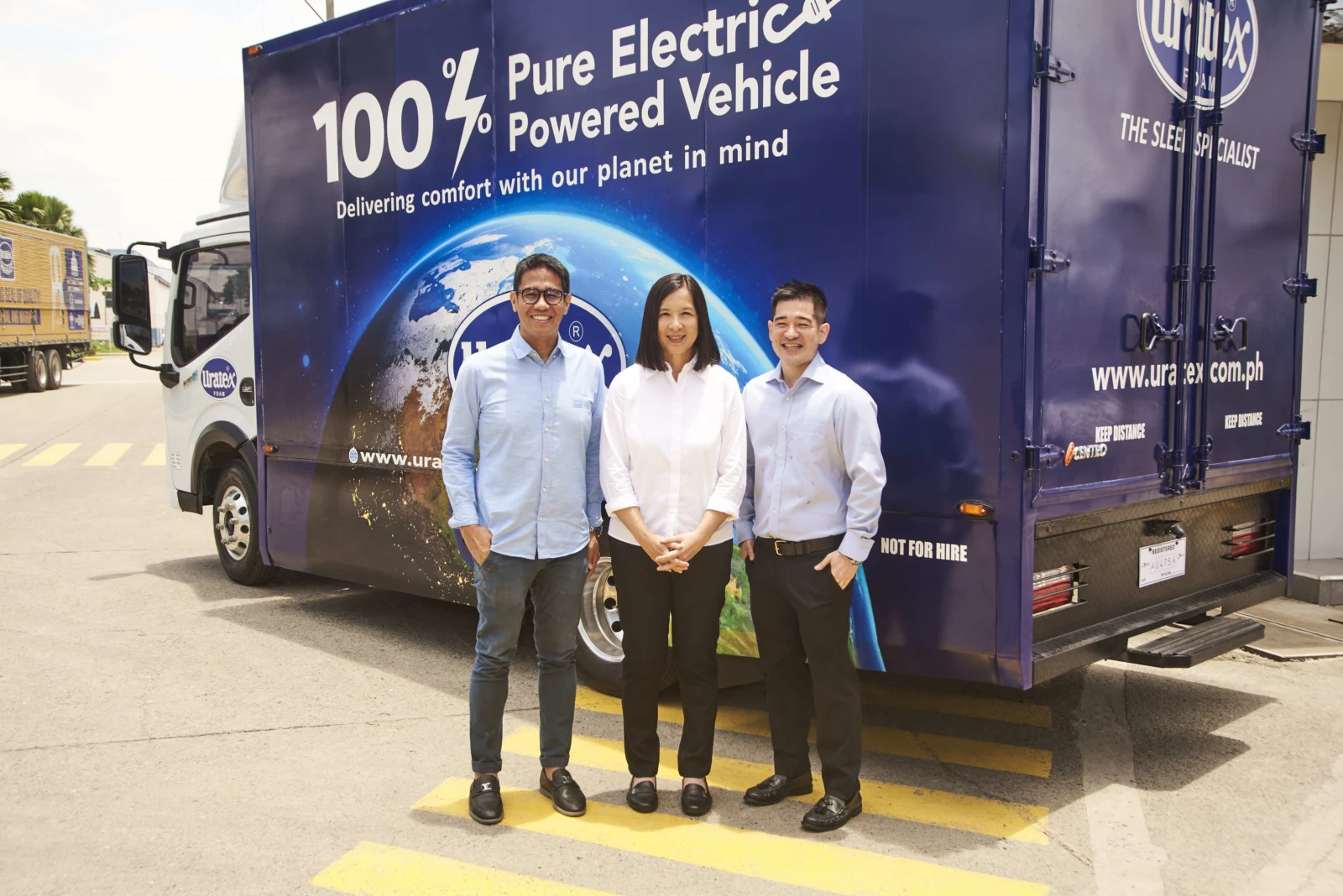 Meralco representatives beside an electric delivery vehicle.