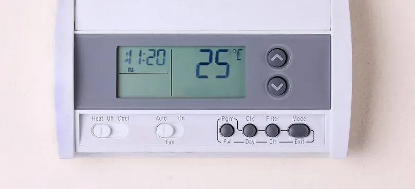 A wall thermostat set to 25°C
