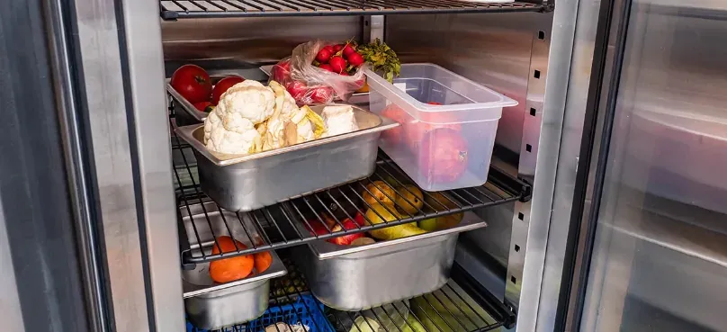 Produce stored in trays inside a commercial chiller