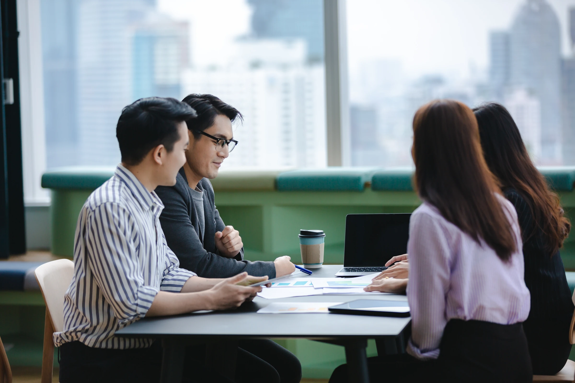 Four colleagues meet around a table.