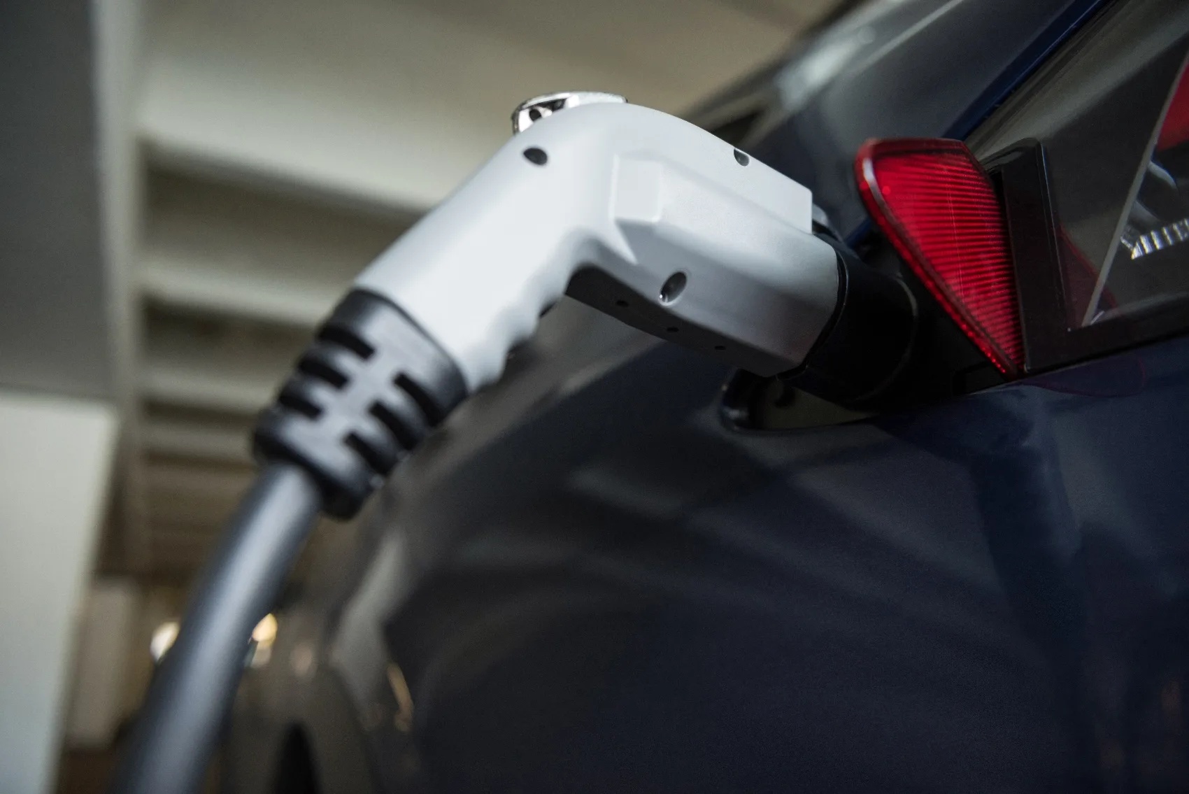 Close-up of a charging connector plugged into an electric vehicle