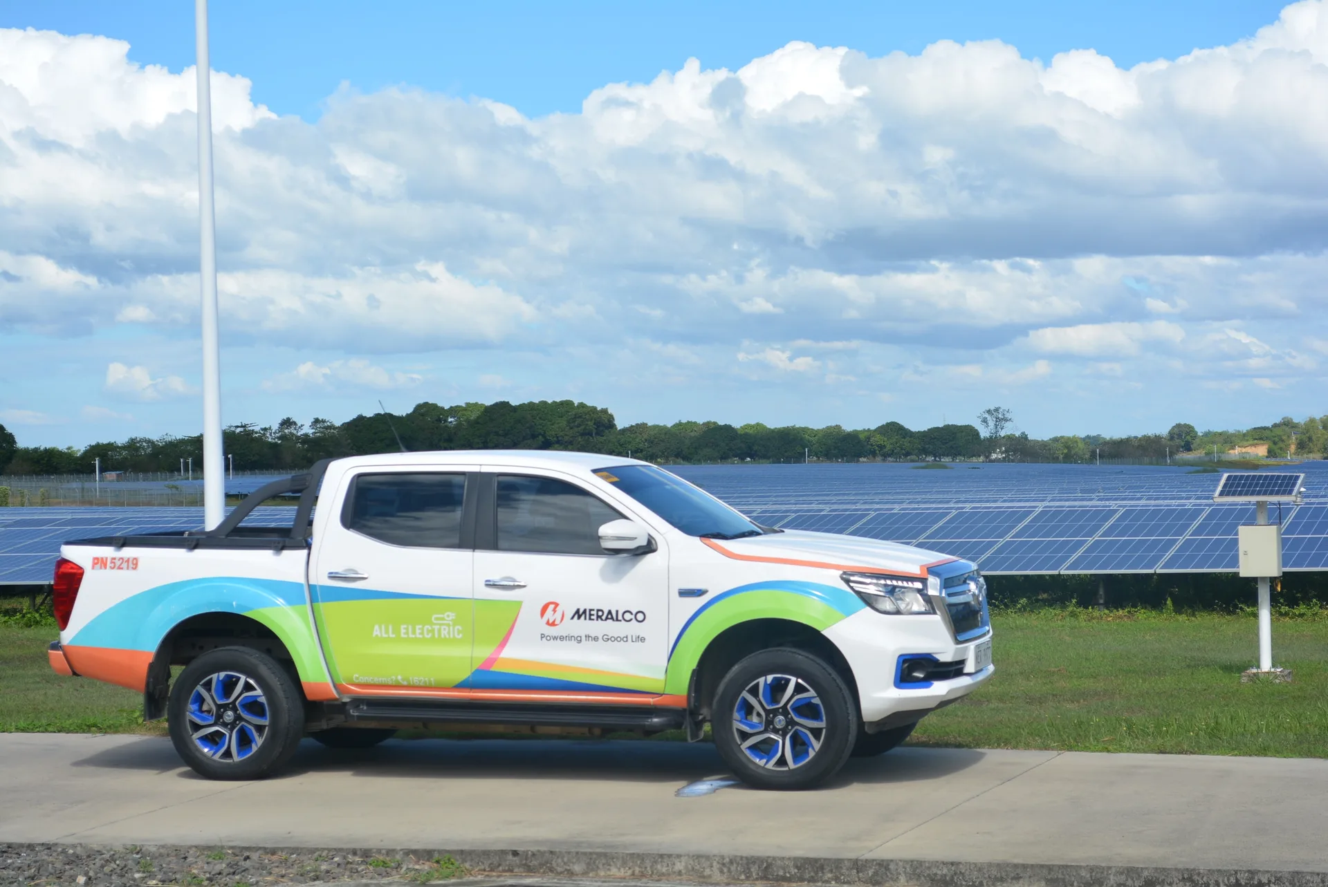 Meralco all-electric vehicle beside a solar installation