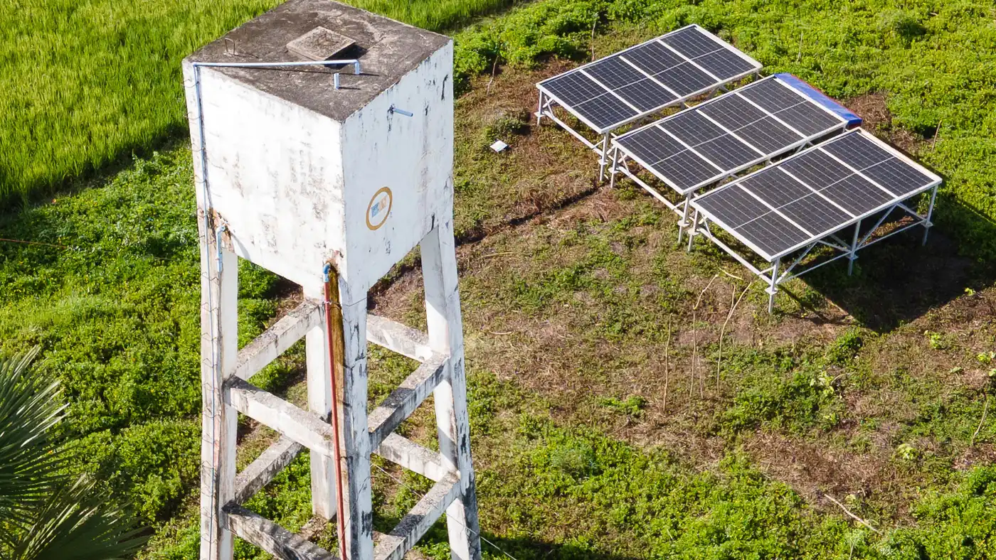 A solar-powered water facility surrounded by agricultural fields.
