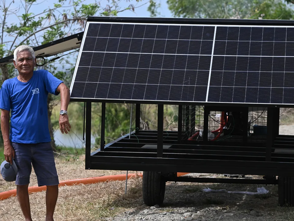 A farmer standing beside a mobile solar-powered irrigation pump in Cuyapo, Nueva Ecija.