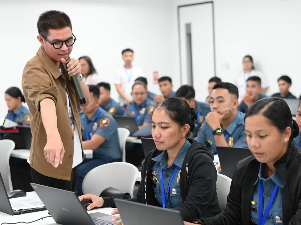 An employee-volunteer guiding public servants during a digital-skills workshop.