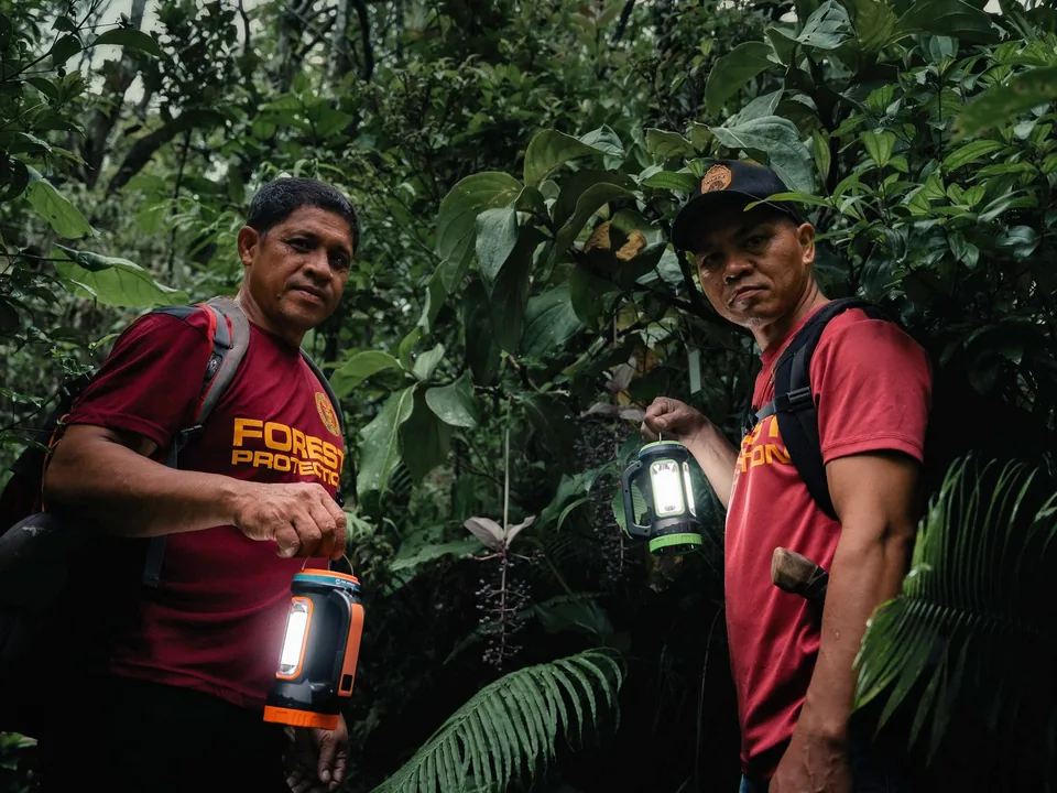 Forest rangers holding solar lamps during a patrol at the UP Laguna-Quezon Land Grant.