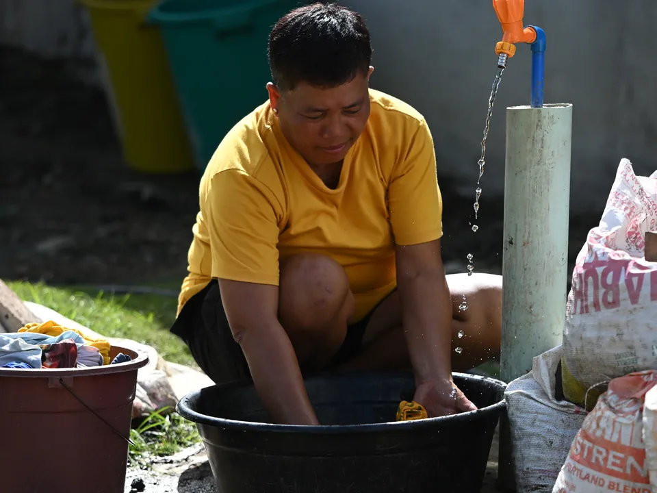 A resident washing clothes beside the solar-powered Sitio Bulabog water system.