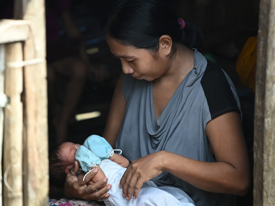Sonia Agawin holding her newborn baby at home on Caponayan Island.