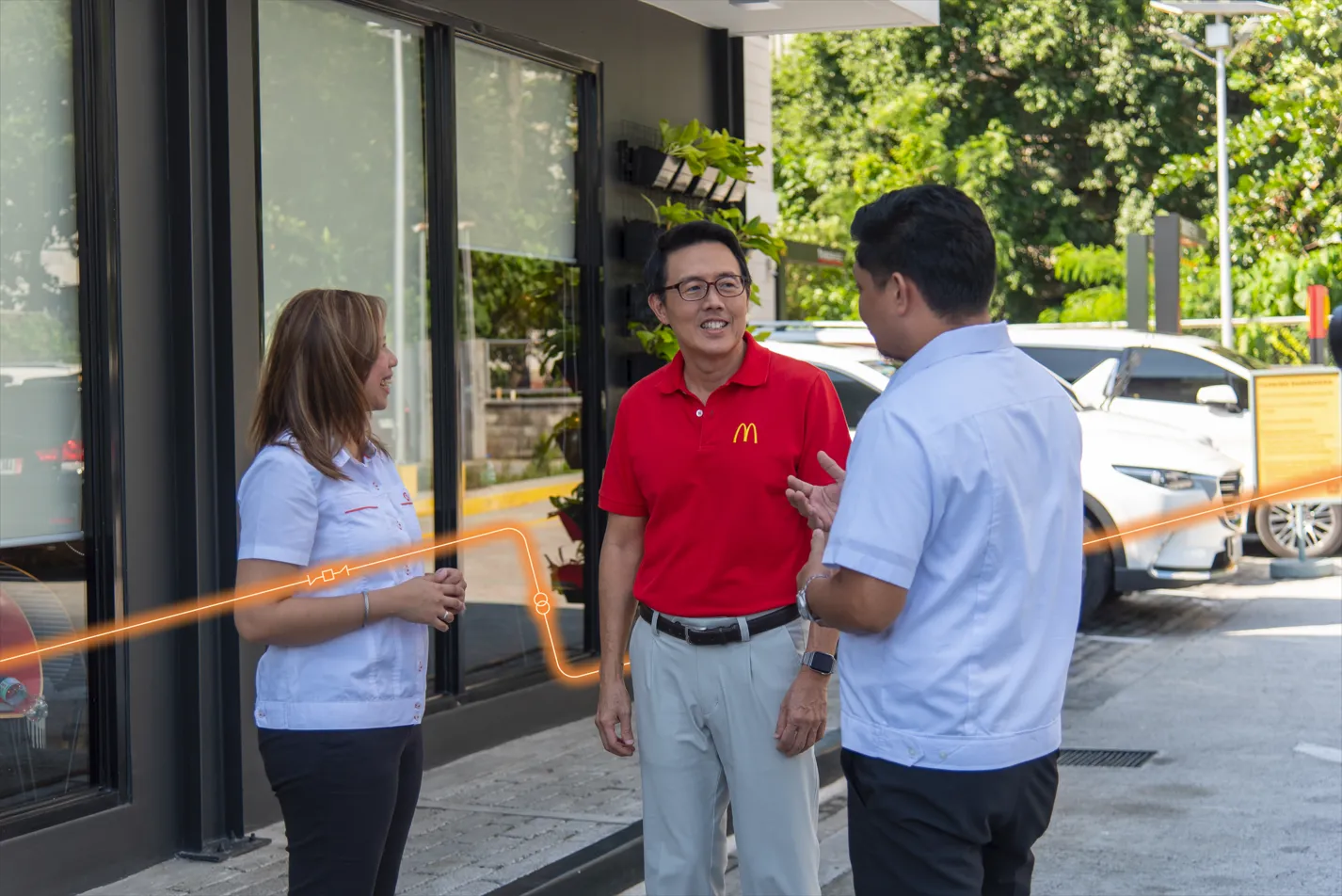 Kenneth S. Yang speaks with Meralco Enterprise representatives Bezie Mina and Allan Anson outside a Green and Good restaurant.