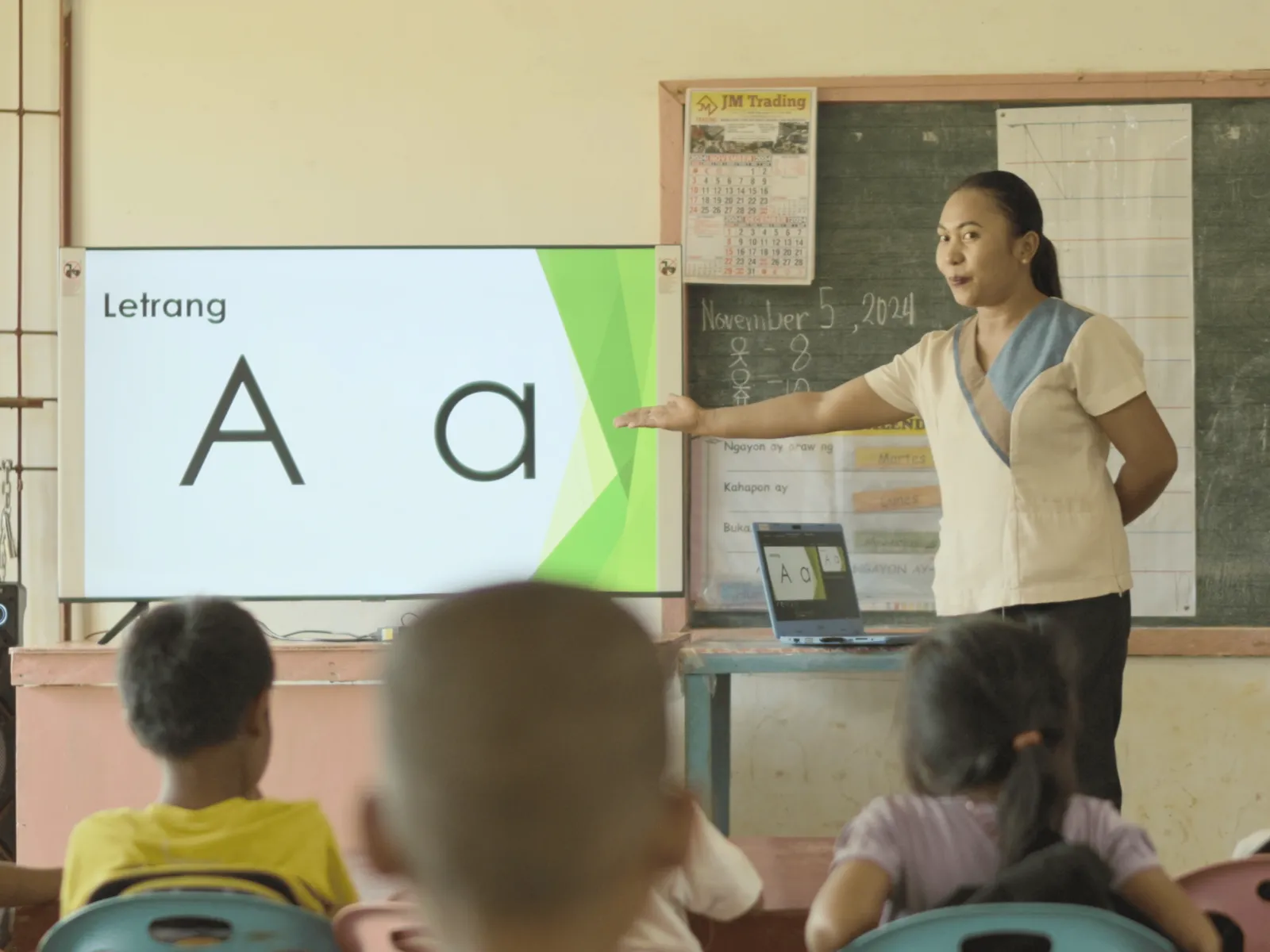 Analyn Miñao teaches letter recognition to students using a classroom display.