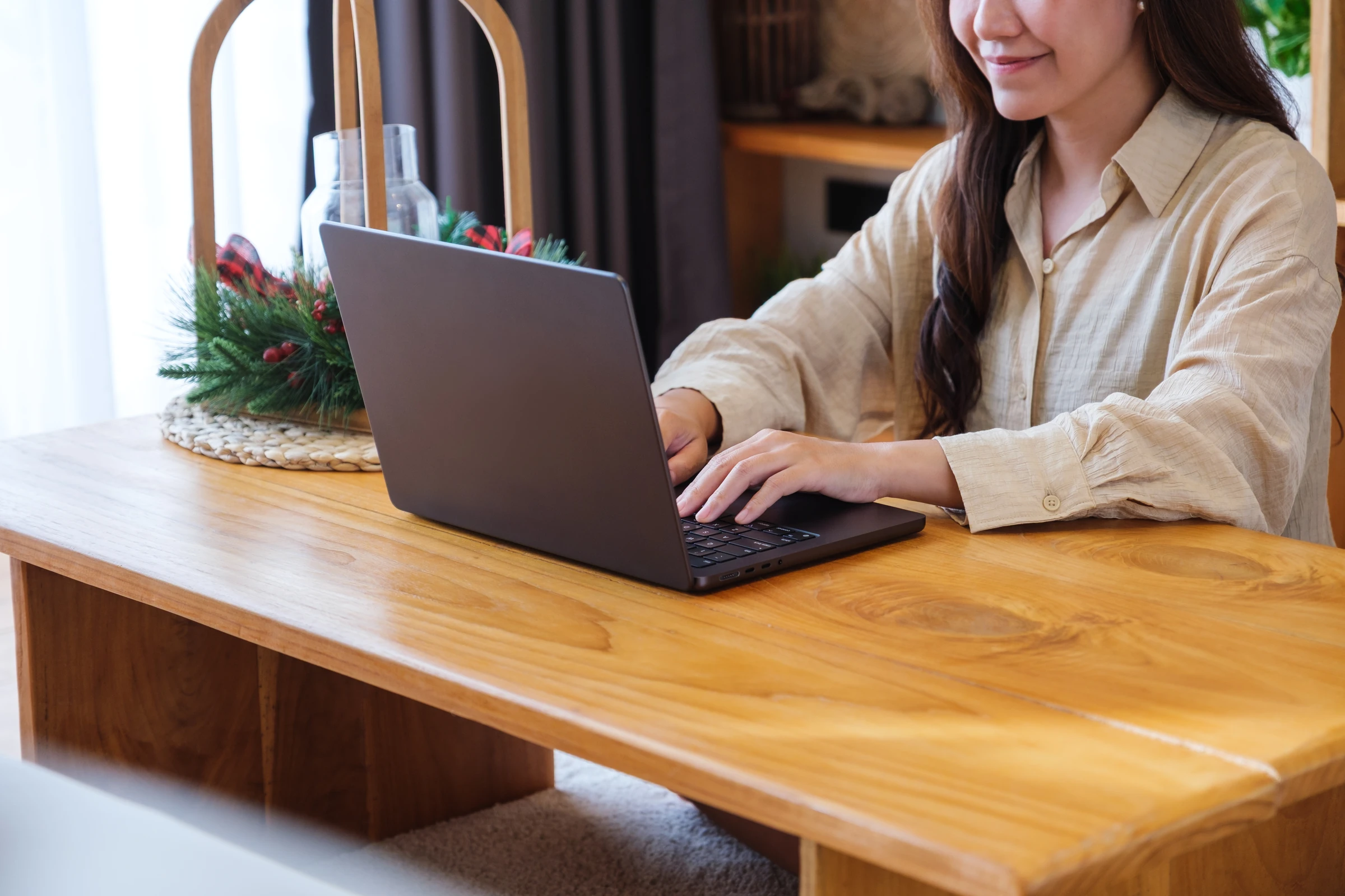 A woman works on a laptop at a cafe table.