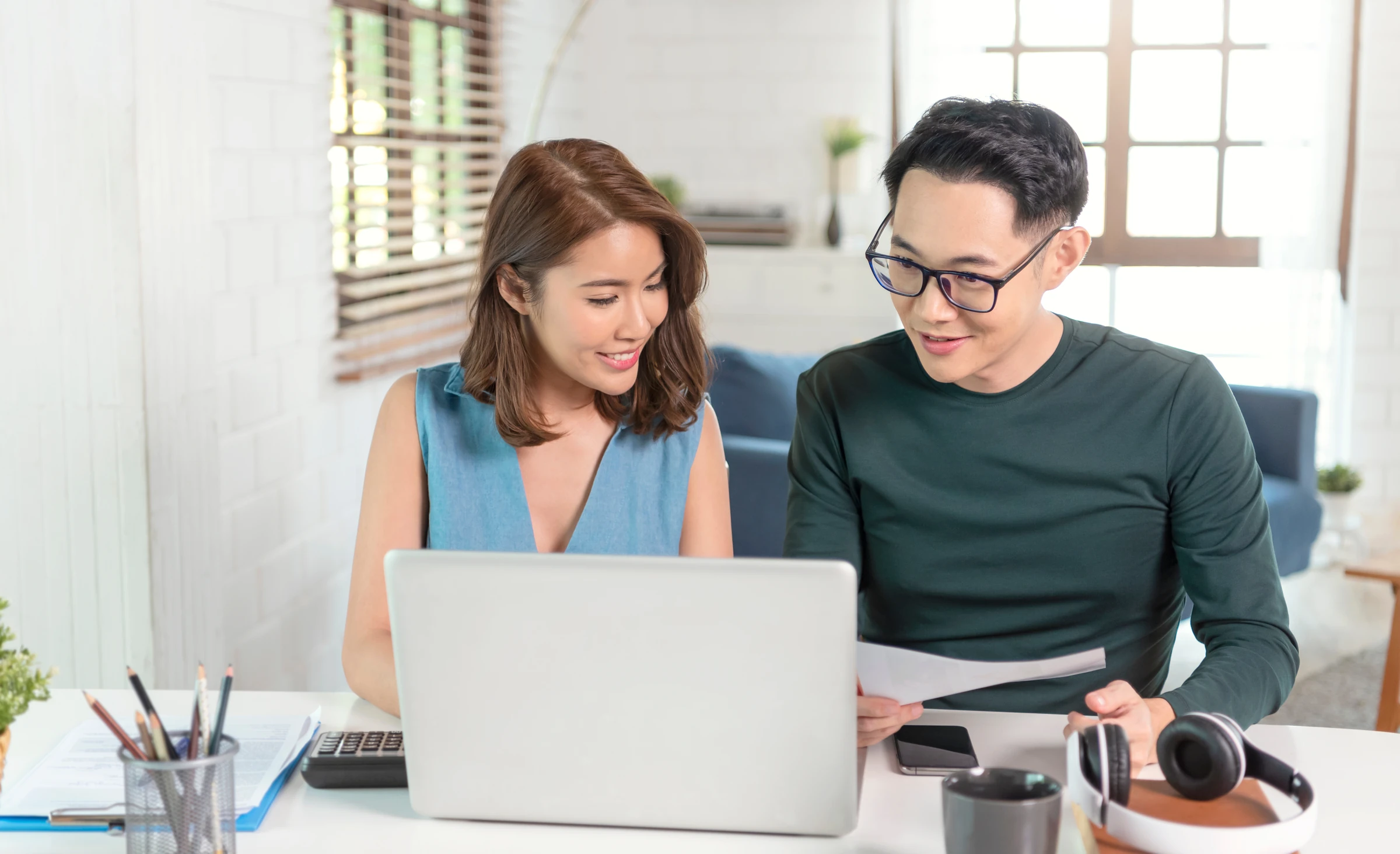 A couple reviews information together on a laptop.